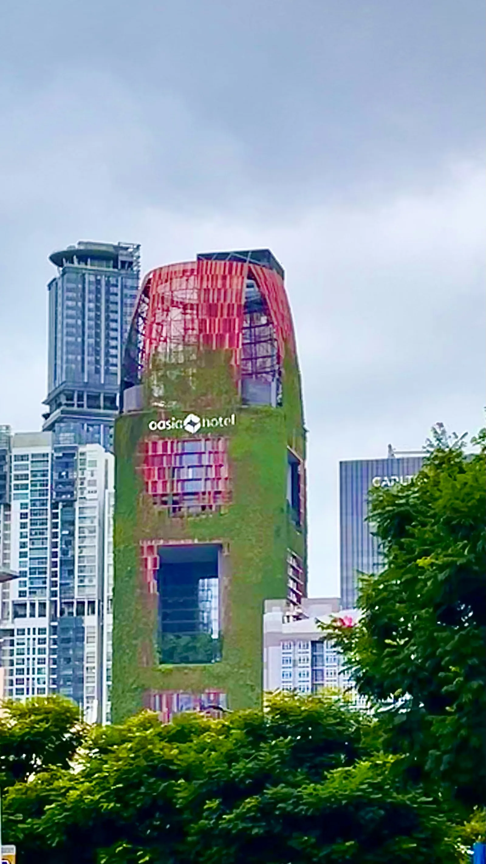 Oasia Hotel em Singapura, com fachada vermelha coberta de plantas