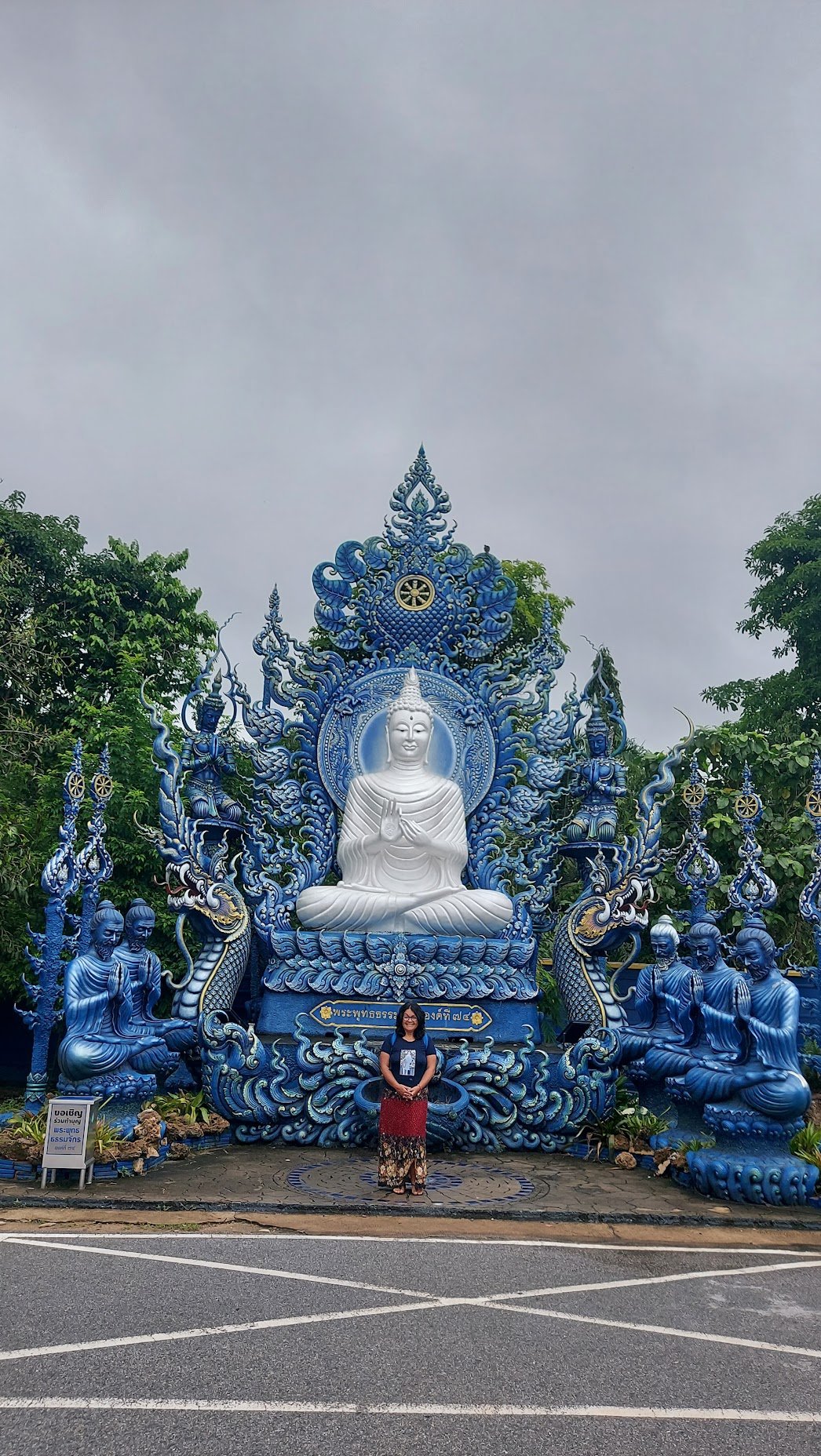Estátua de Buda branca decorada com detalhes em relevo azul e dourado no complexo do Templo Azul em Chiang Rai, na Tailândia