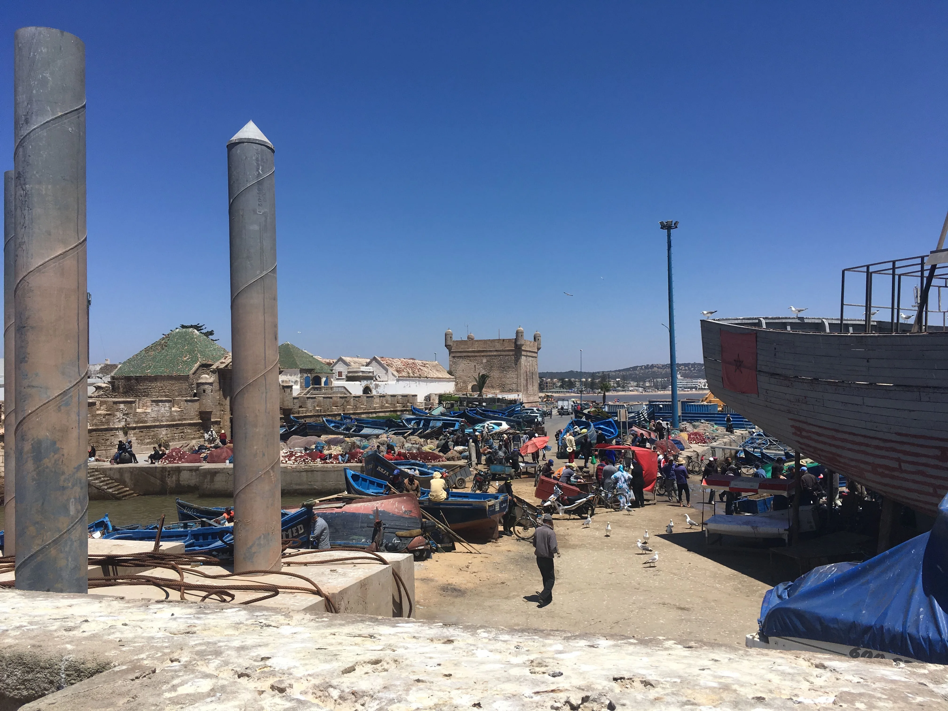 Cais do porto de Essaouira com vários barcos de pesca azuis enfileirados