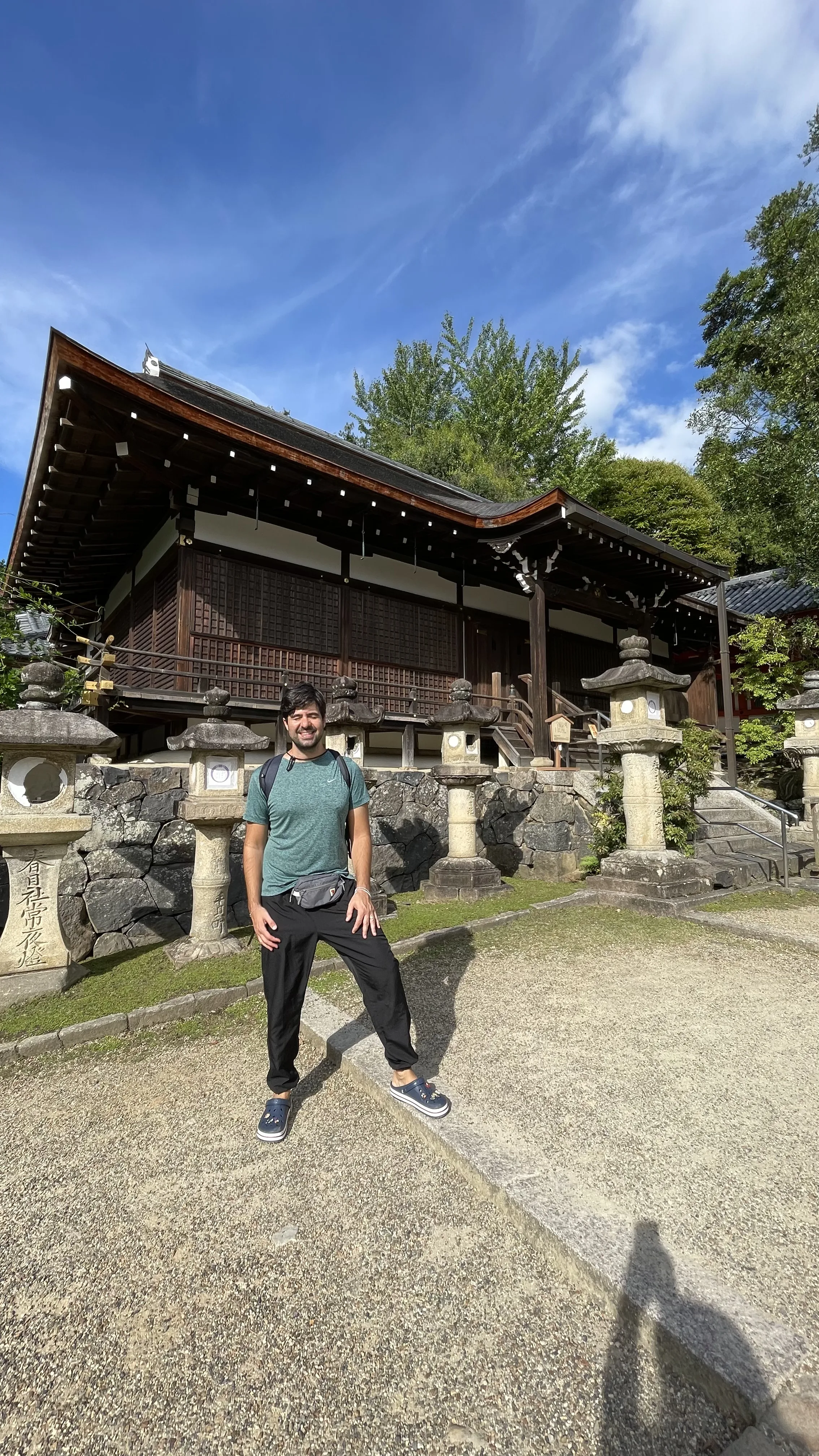 Turista sorridente posa entre lanternas de pedra no templo todaji em Nara, no Japão.