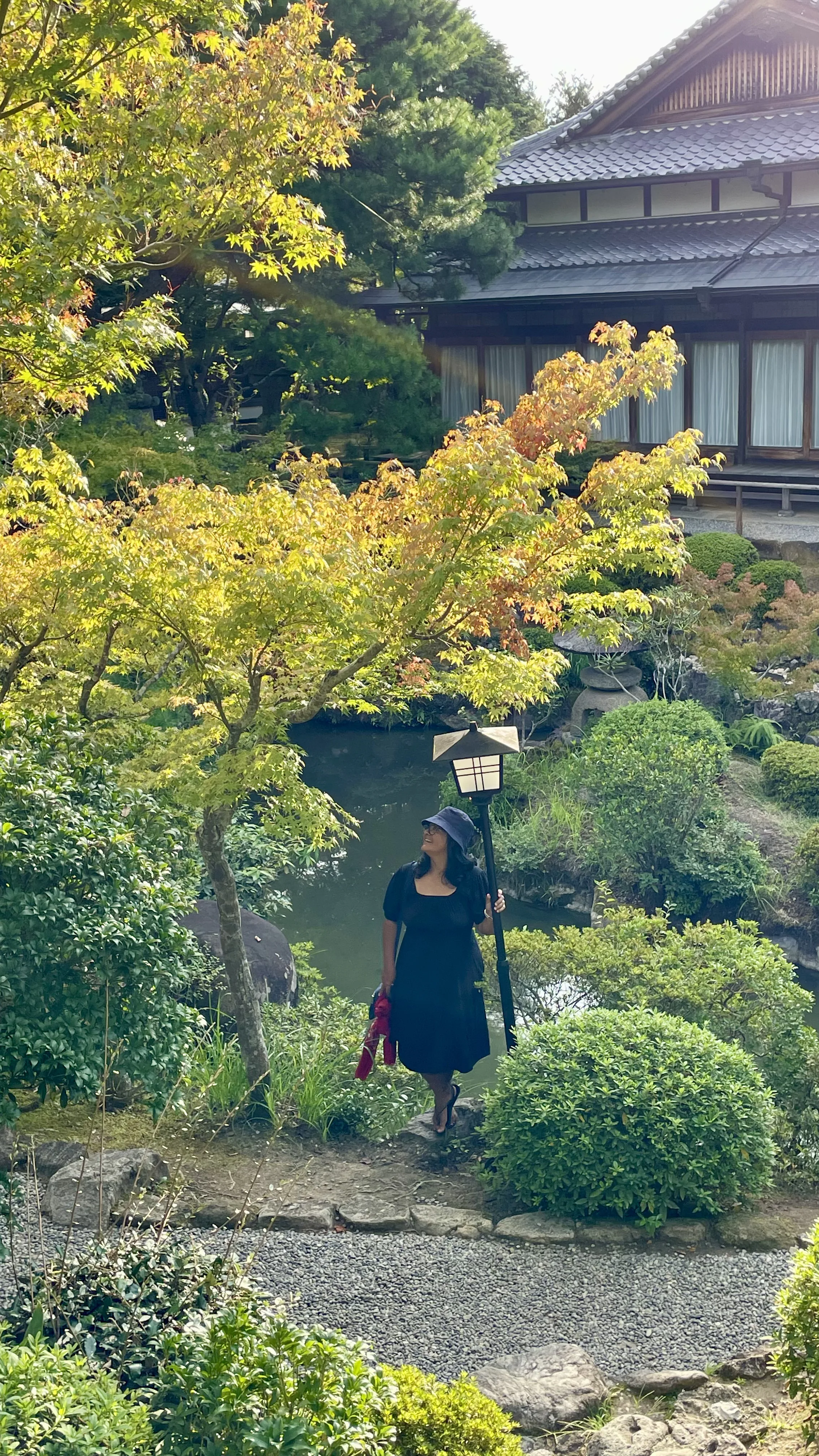Turista posa perto de lago no tradicional Jardim Yoshikien em Nara, belo ponto turístico e cenário natural no Japão.