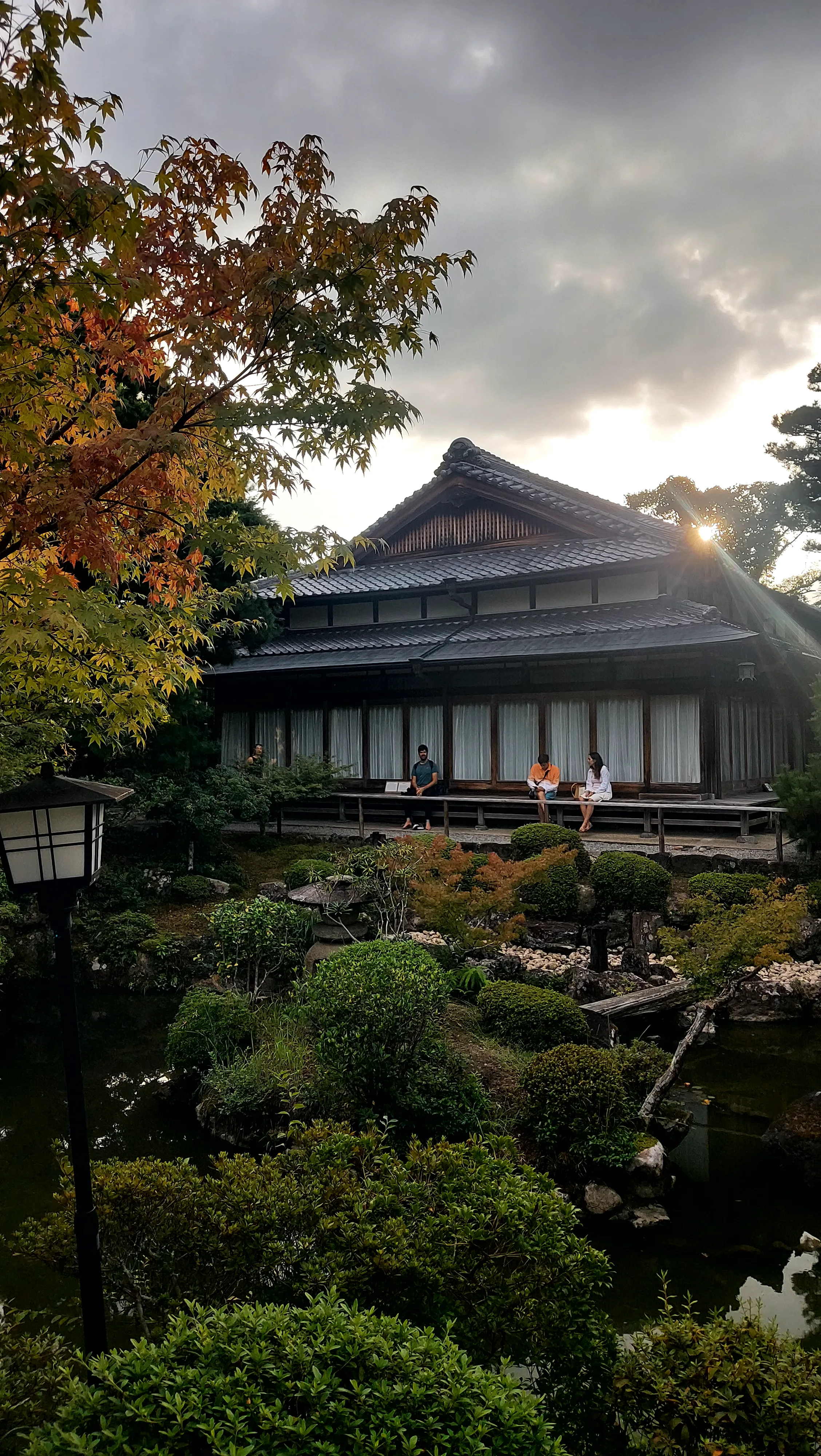 Turistas relaxam na varanda da casa de chá do Jardim Yoshikien em Nara, belo ponto turístico tradicional no Japão.