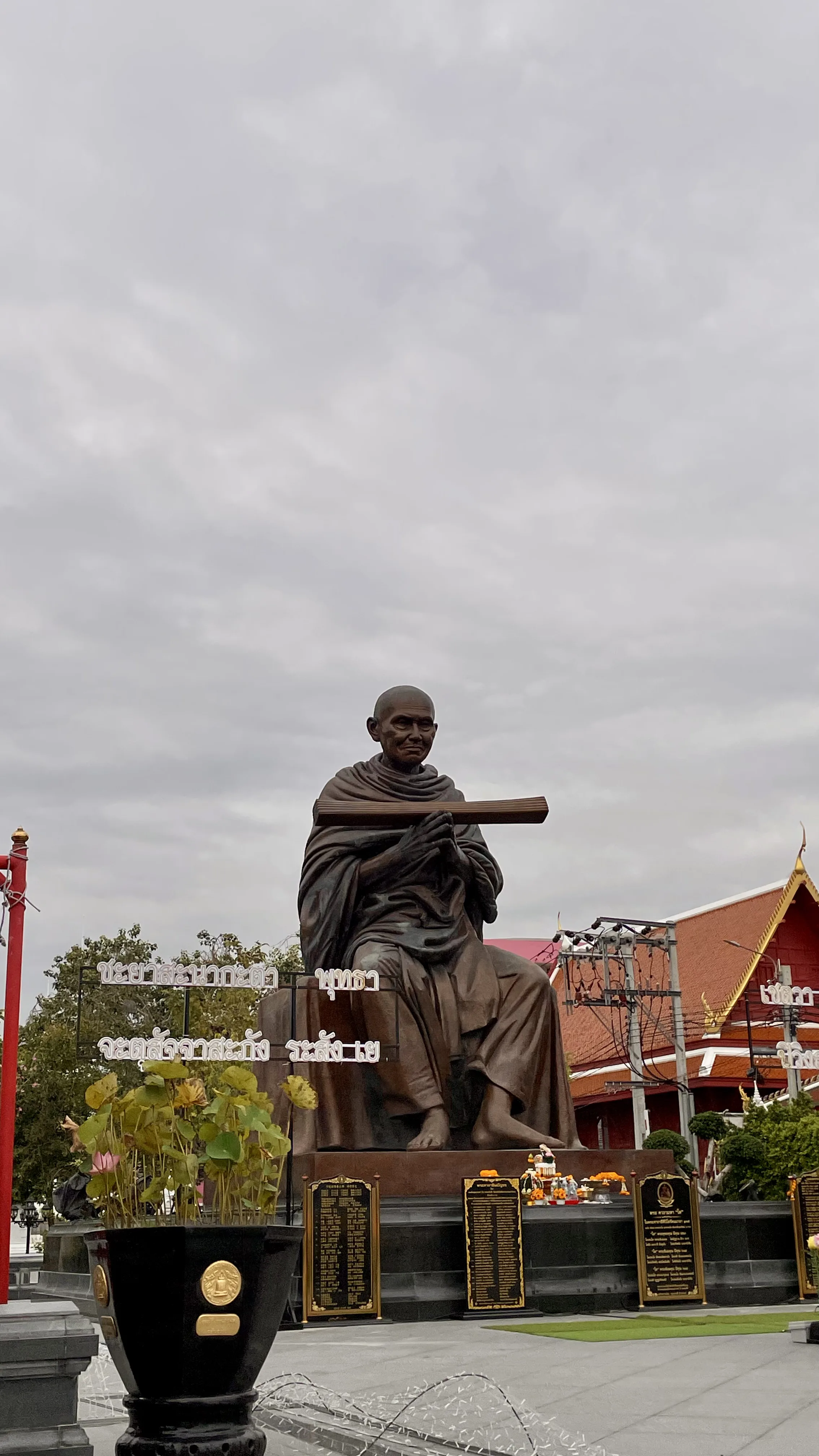 Estátua de bronze do venerado monge Somdej Toh sentado ao ar livre no complexo do Wat Rakang Khositaram, em Banguecoque.