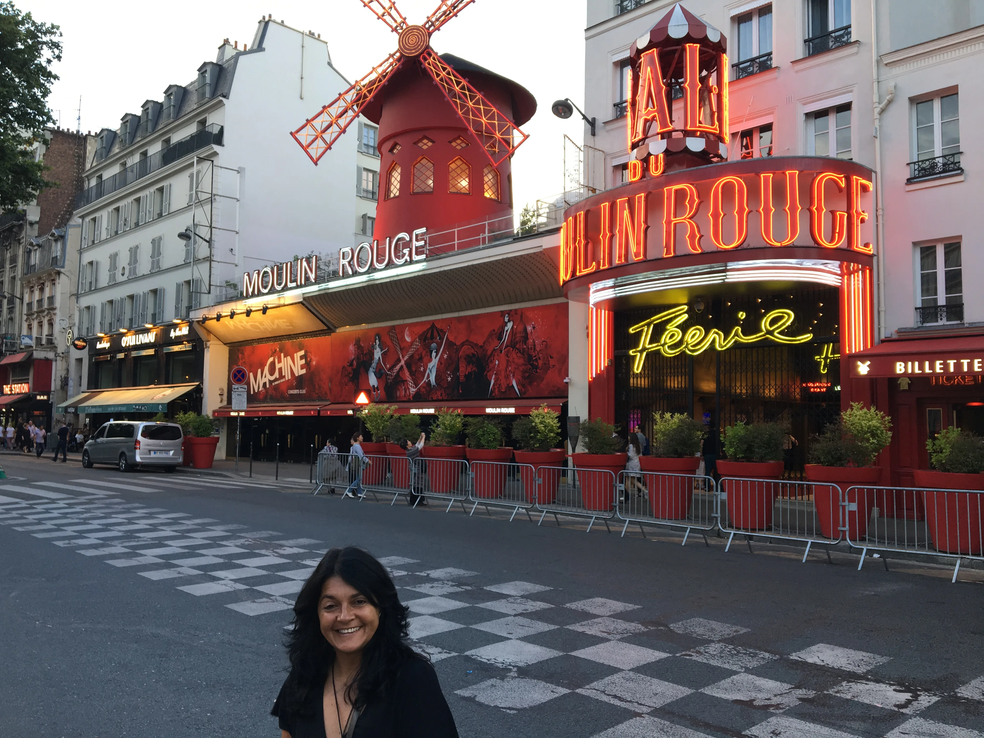 Fachada iluminada do cabaré Moulin Rouge com o tradicional moinho vermelho em Paris