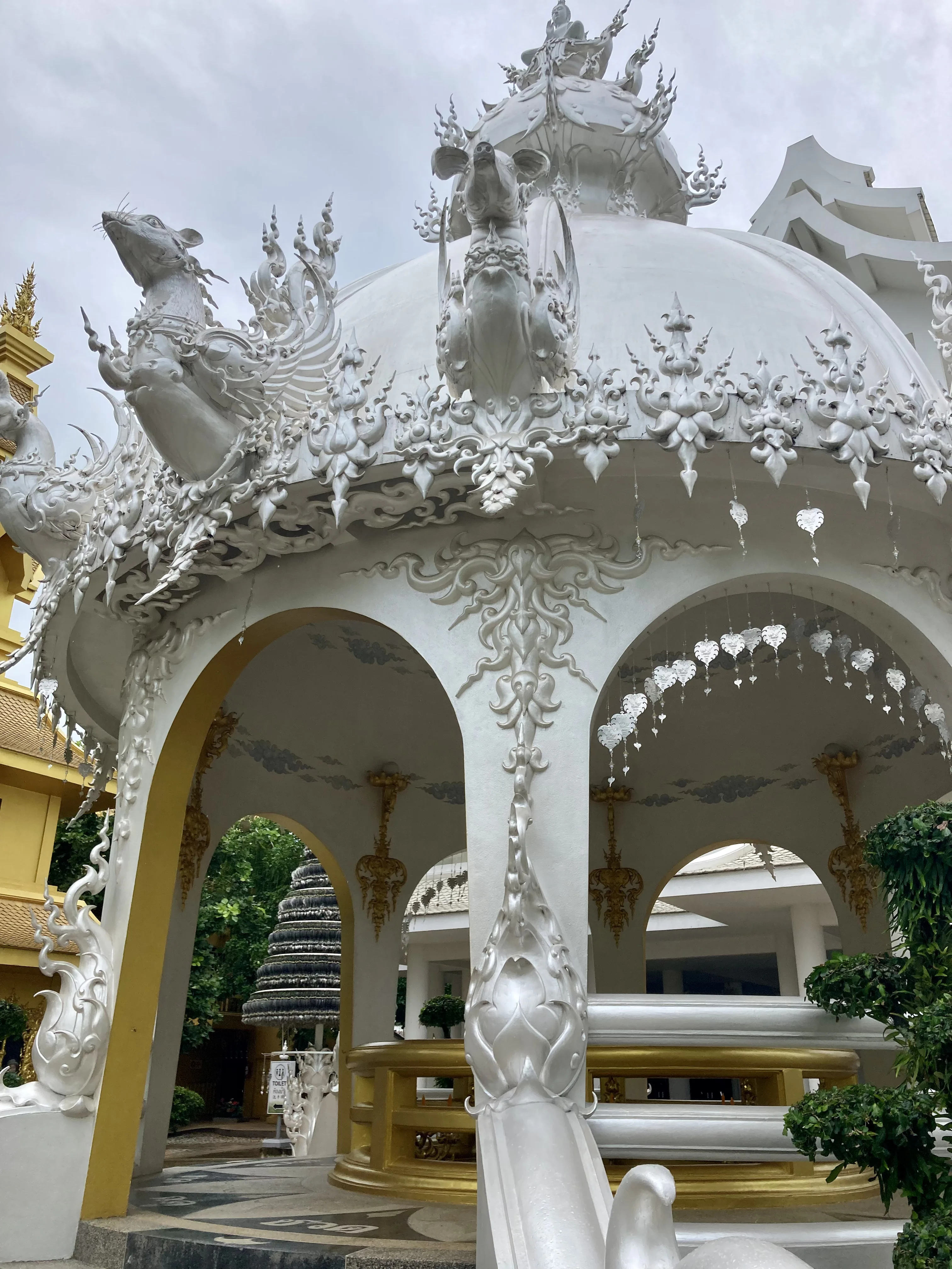 Construção dourada ornamentada na área externa do Templo Branco em Chiang Rai