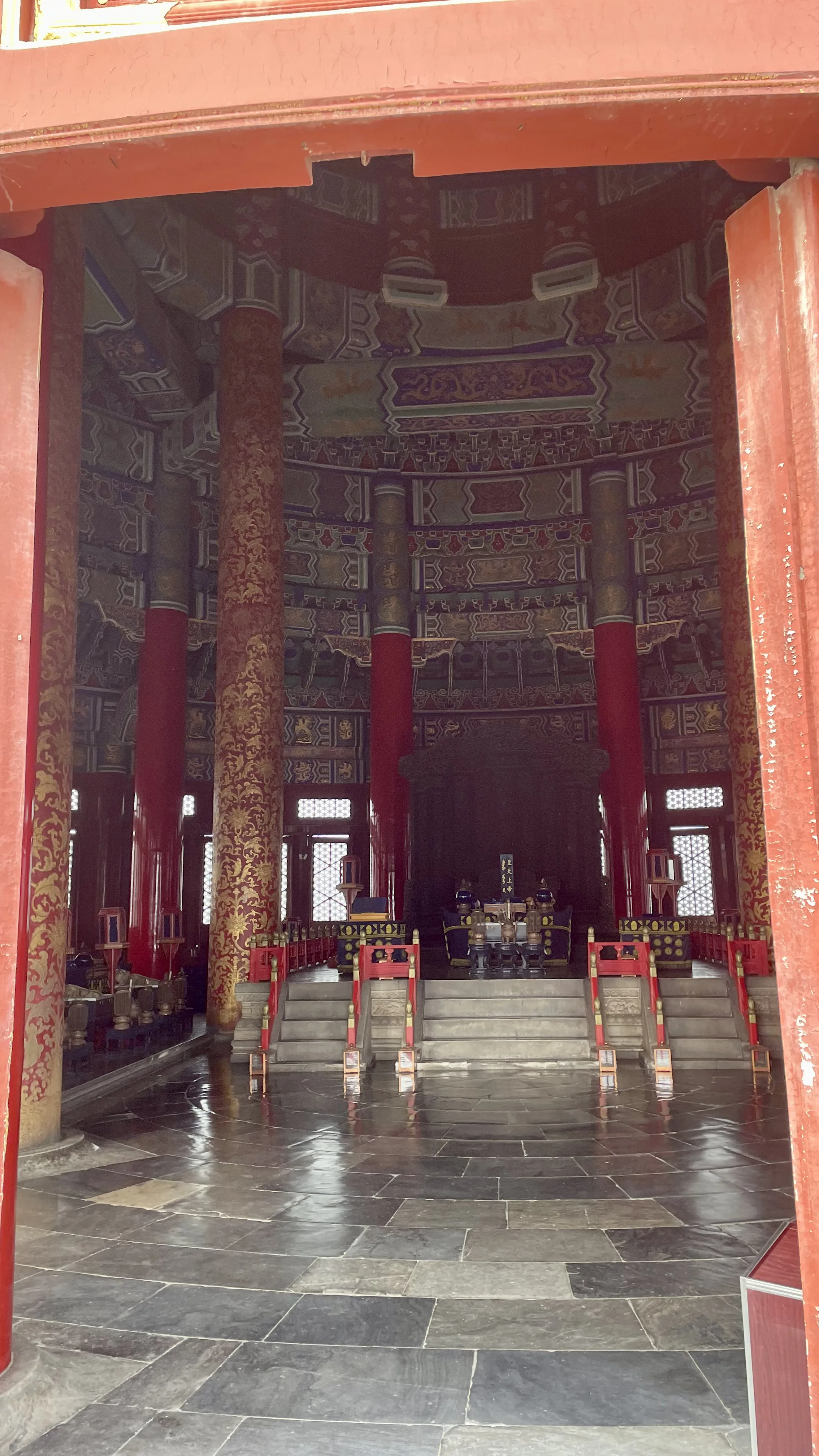 nterior do Salão de Orações para Boas Colheitas no Templo do Céu exibindo pilares vermelhos ornamentados e teto decorado em Pequim.