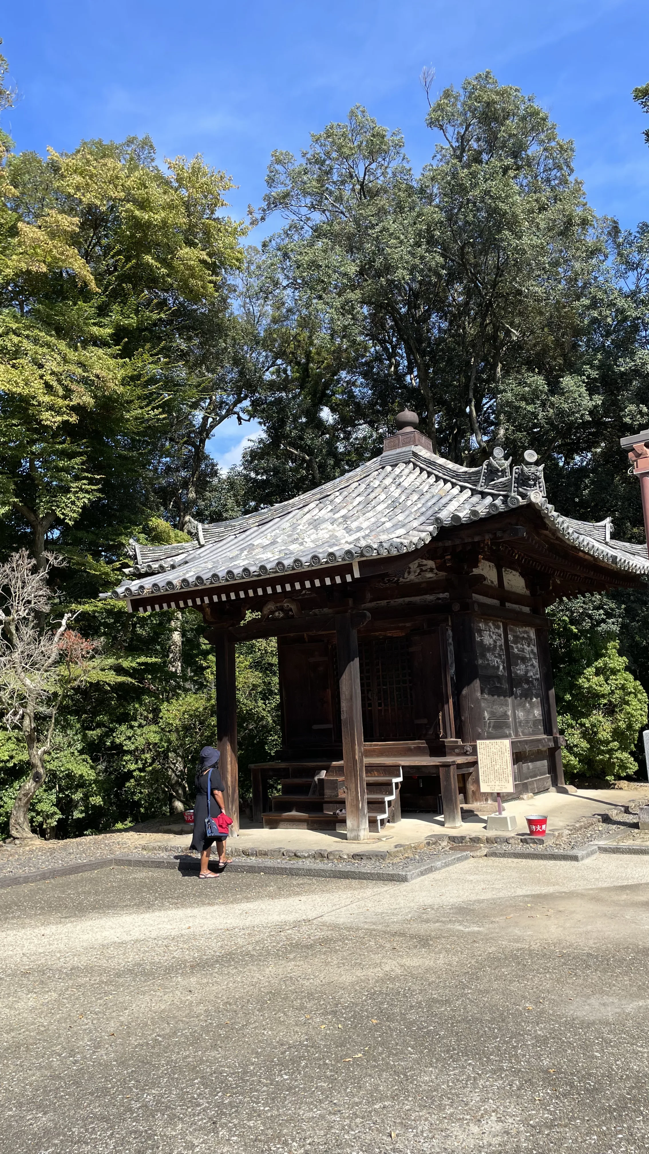 Turista caminha perto do histórico pavilhão Gyoki-do no complexo do Templo Todaiji em Nara, destino turístico no Japão.