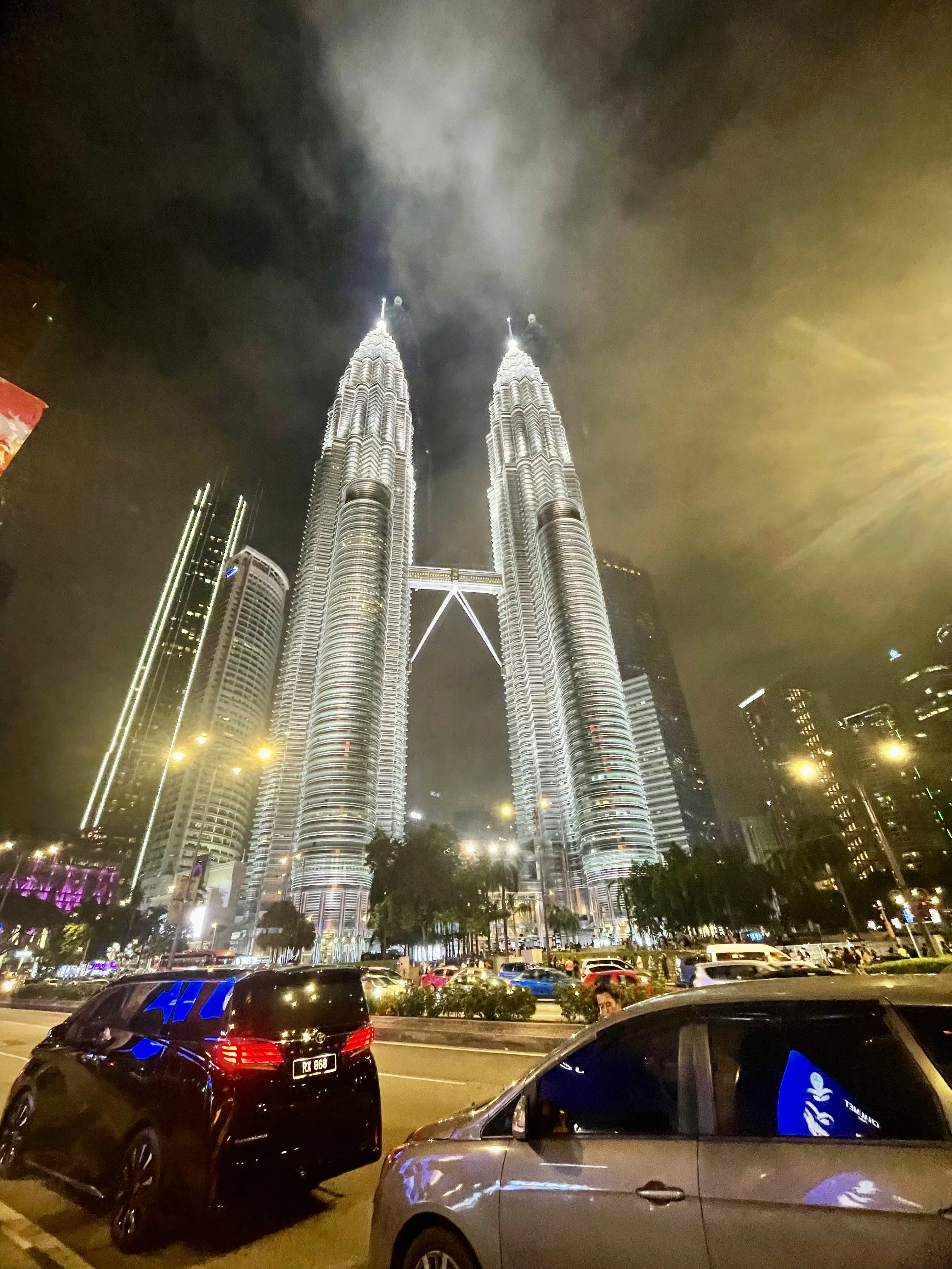 Vista das Torres Petronas iluminadas à noite em Kuala Lumpur, Malásia.