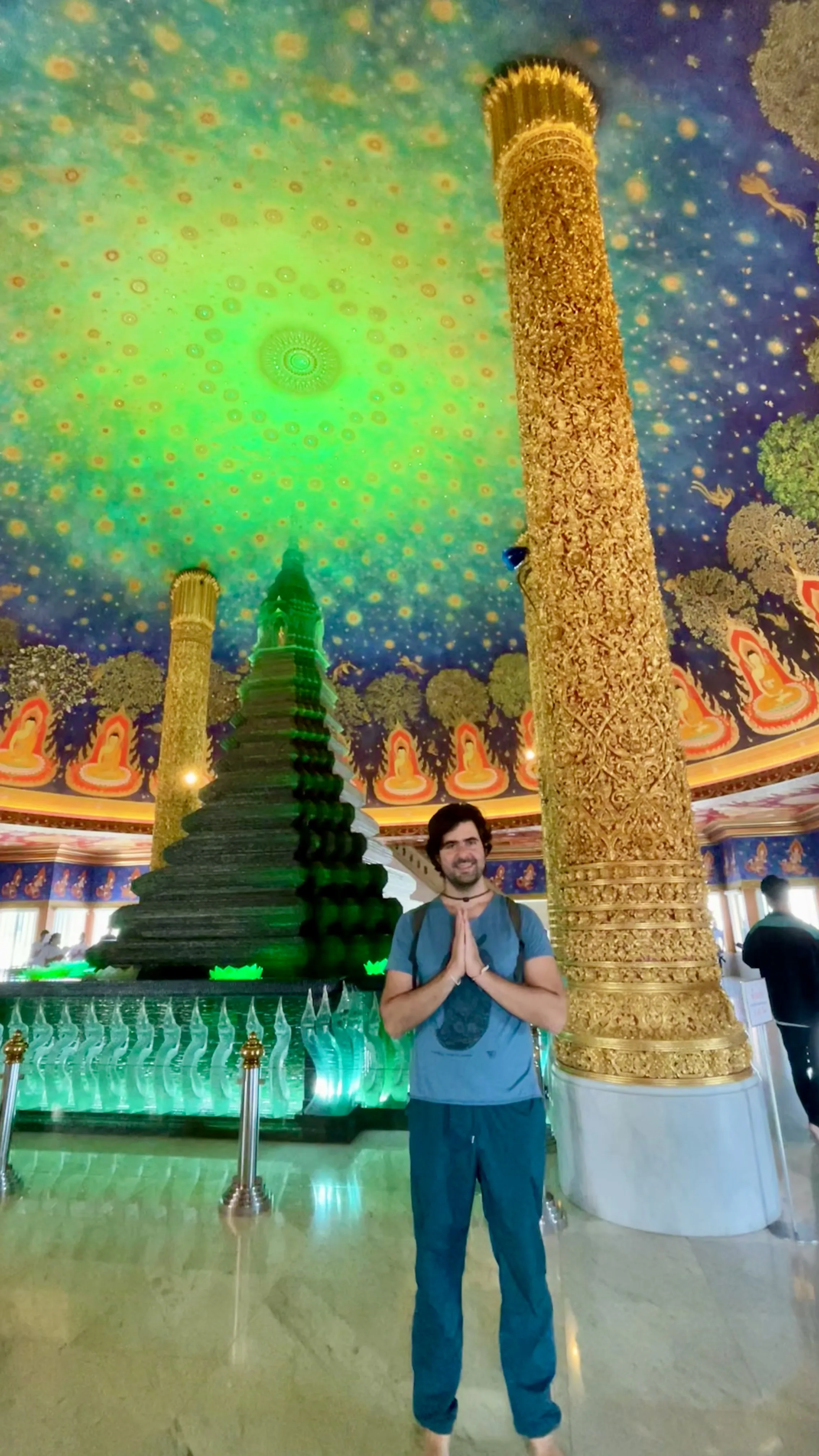 Estupa de vidro verde esmeralda sob teto pintado como galáxia no interior do Wat Paknam Phasi Charoen em Bangkok.
