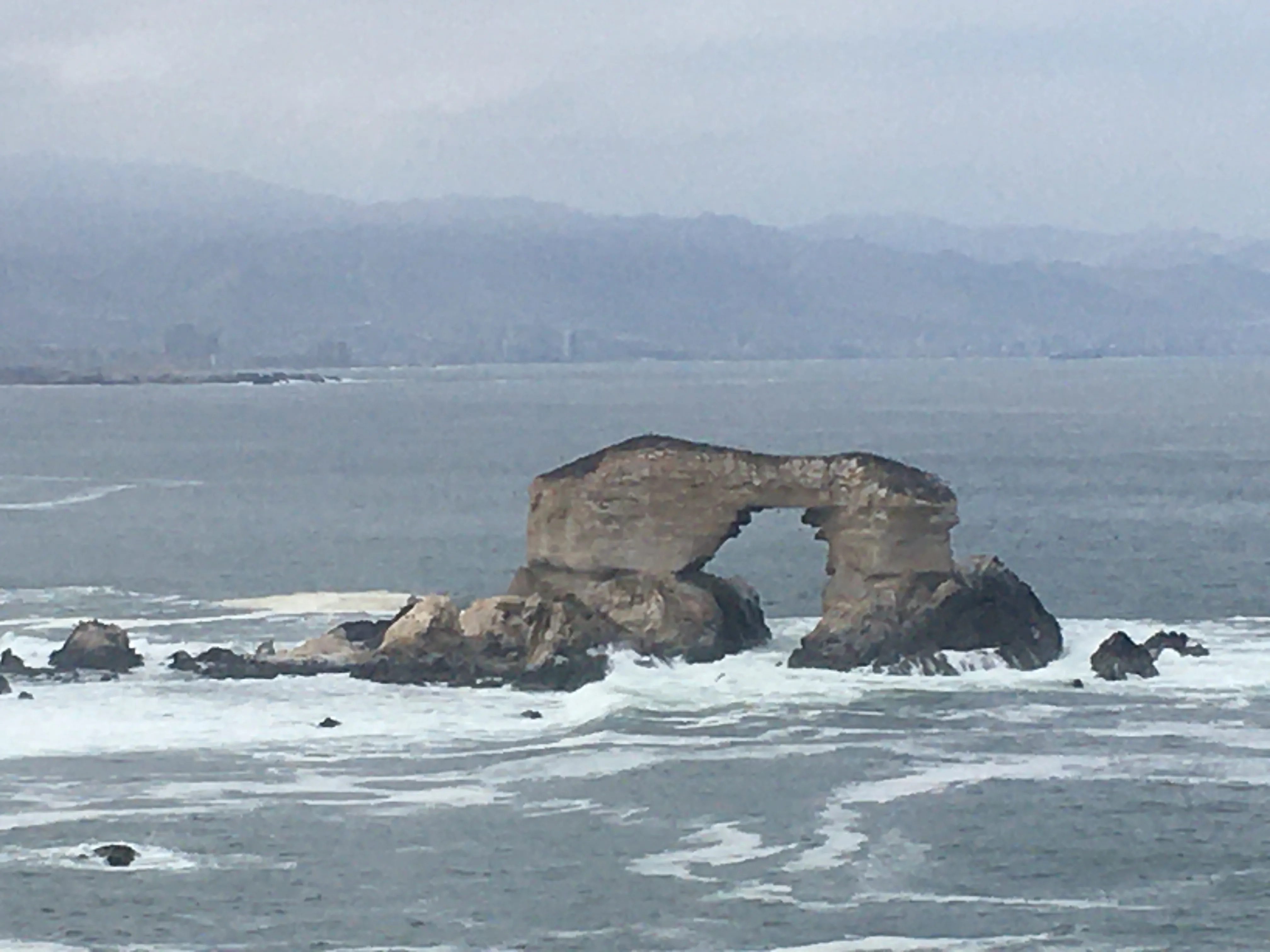 O famoso arco rochoso natural de pedra do Monumento Natural La Portada erguendo-se sobre as águas agitadas do Oceano Pacífico em Antofagasta, Chile.