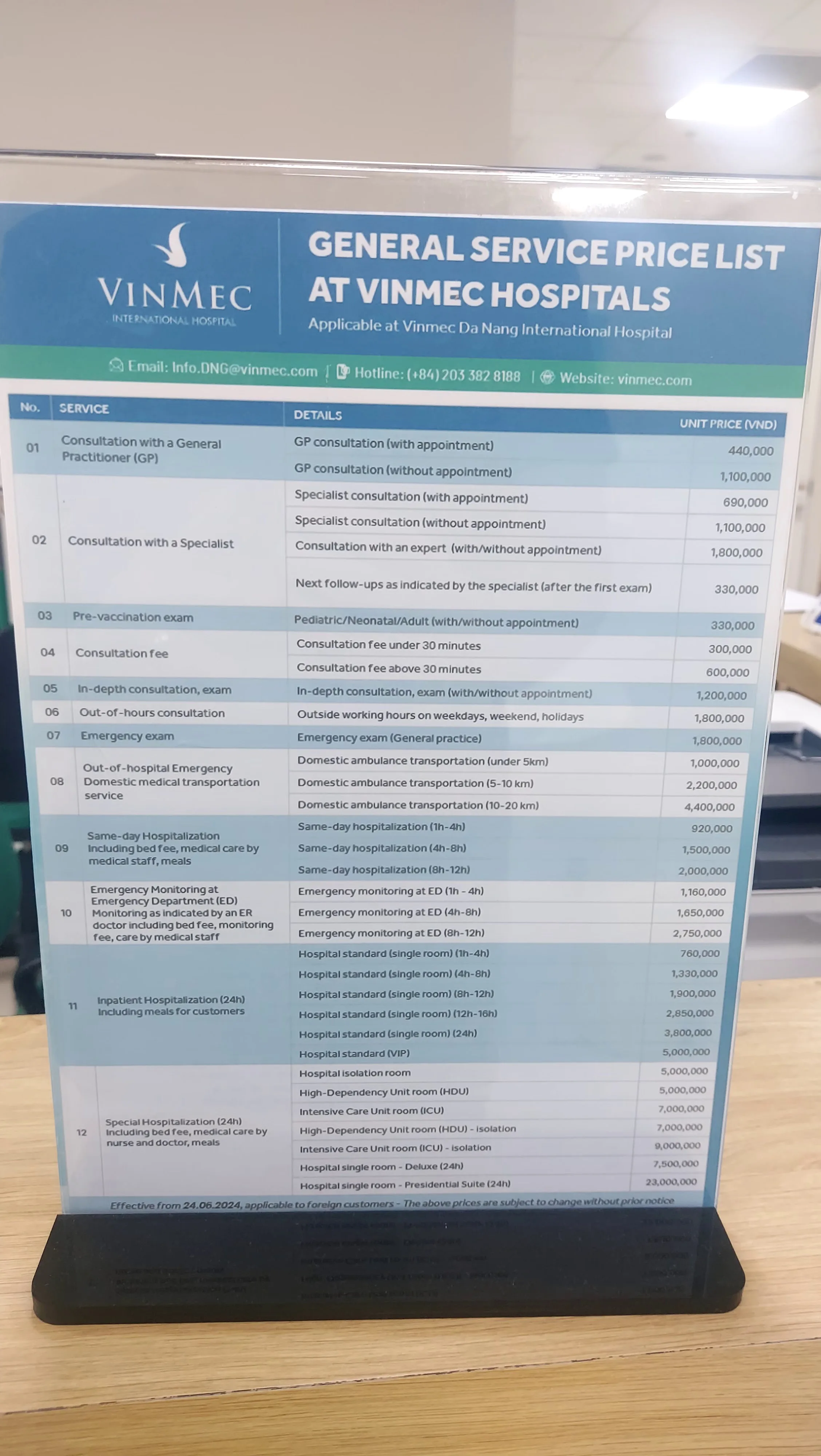 Display em balcão com tabela de preços em dongs para consultas e emergência no Vinmec International Hospital em Da Nang no Vietnã.