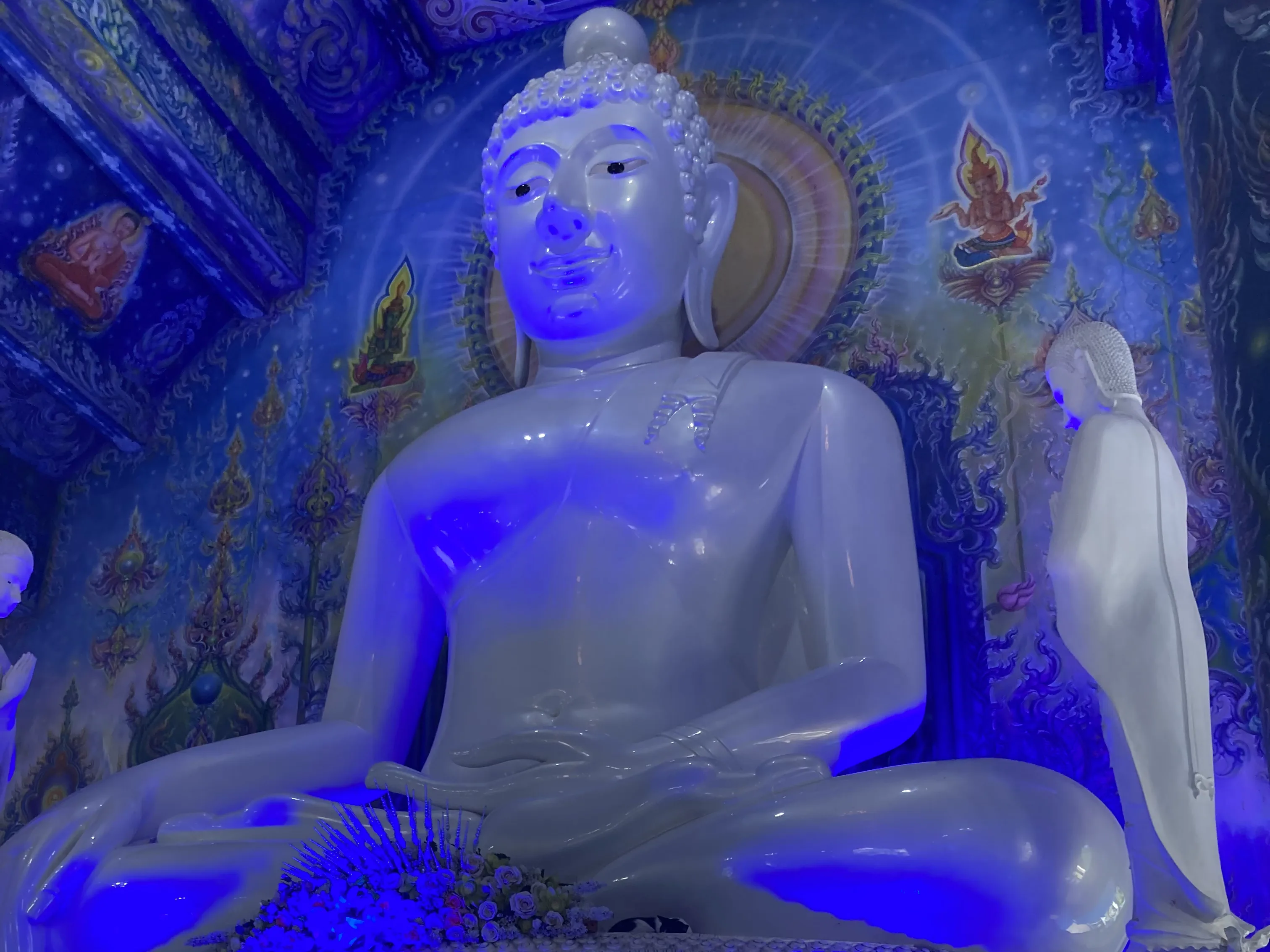 Grande estátua de Buda branca com iluminação azul no interior do Templo Azul em Chiang Rai, na Tailândia.