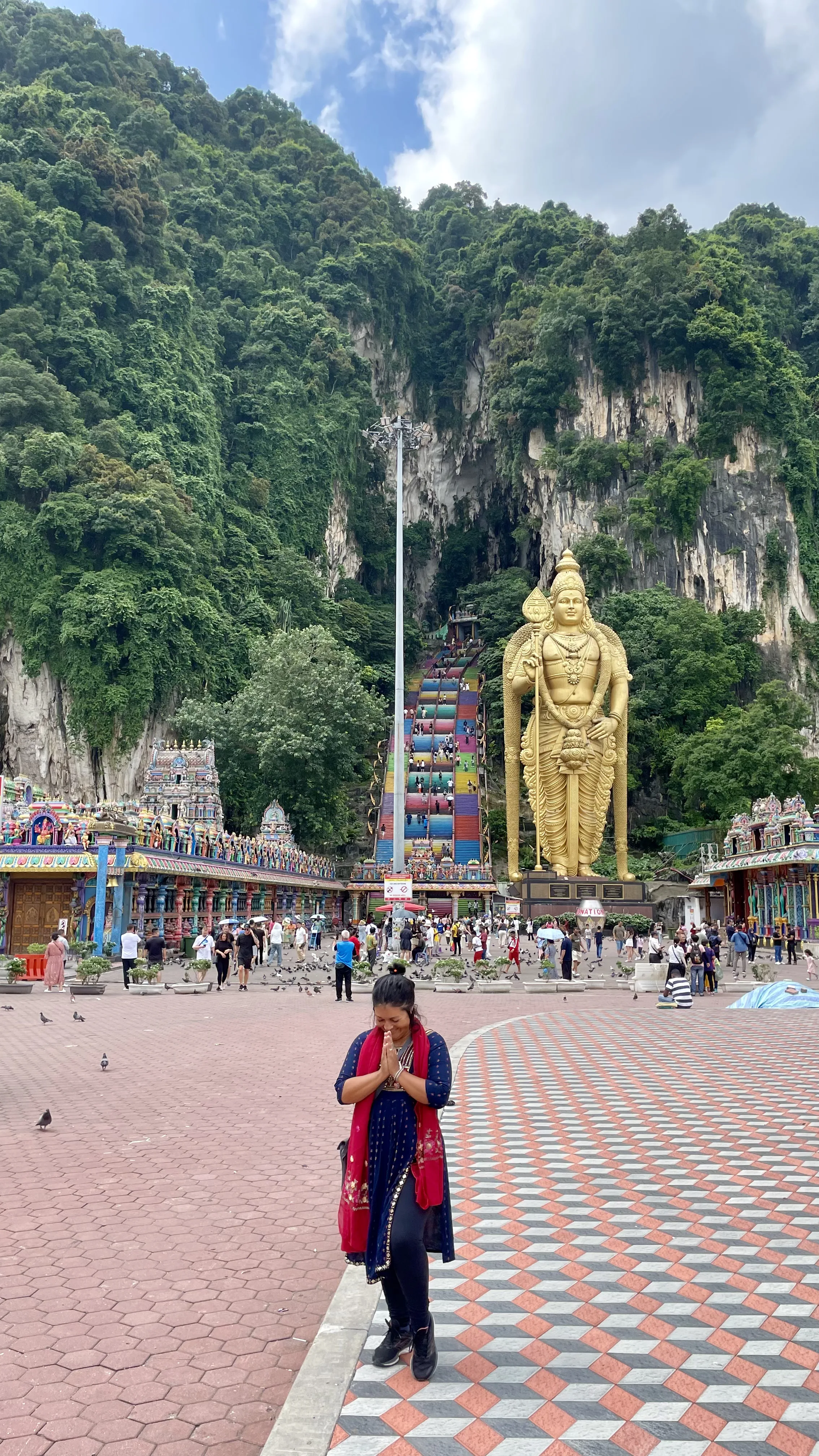 Estátua dourada gigante de Murugan e escadarias coloridas de Batu Caves na Malásia.