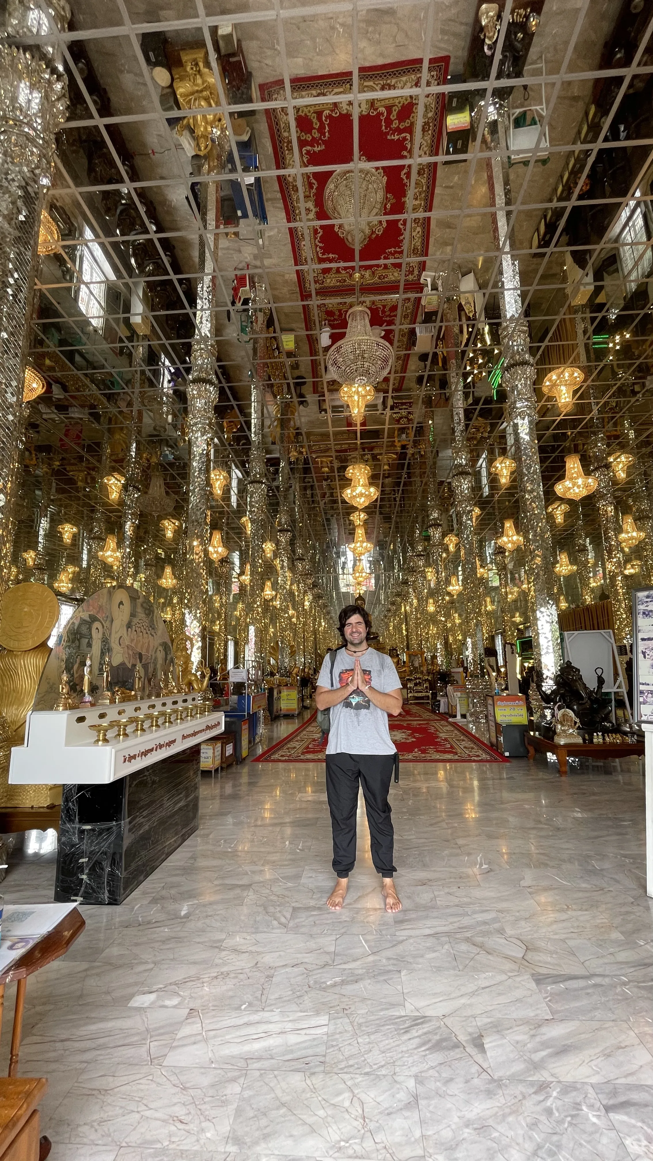 Interior do salão de espelhos Wihan Kaew com pilares espelhados e imagens de Buda